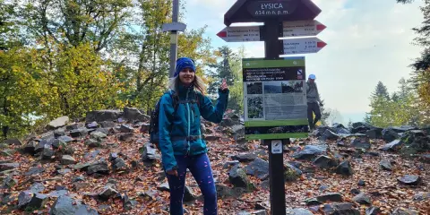 Kobieta na szczycie Łysicy, 614 m n.p.m., przy drogowskazie szlak łysica - kakonin. Jesień w pełni, liście na ziemi.
