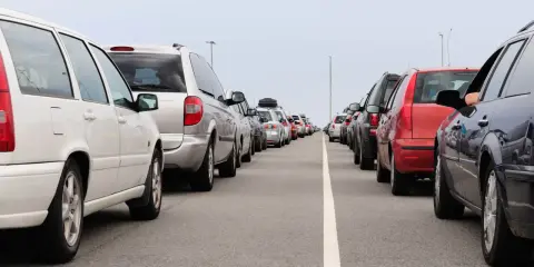 Fila de coches en carretera. Evita la multa por adelantar en línea continua.
