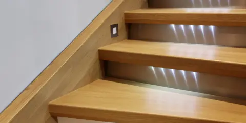 Escalier en bois rénové avec éclairage LED discret. Un design moderne pour un escalier chaleureux.