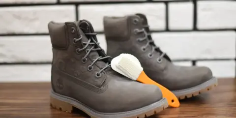Szare Timberlandy i szczoteczka do czyszczenia. Dowiedz się, czym czyścić timberlandy, by służyły latami.
