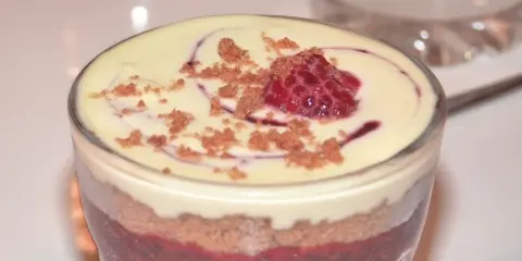 Verrine speculoos framboise : couches de biscuits émiettés, compotée de framboises et crème onctueuse, surmontée d'une framboise fraîche et miettes de spéculoos.