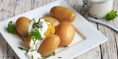 Kleine, goldbraune Kartoffeln mit cremigem Quark und frischem Schnittlauch garniert. Ein Klassiker: Kartoffeln mit Quark.