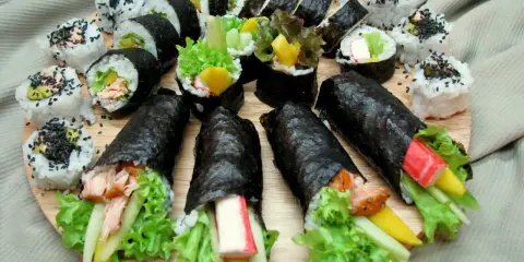 Talerz pełen pyszności: sushi z łososiem, awokado, krabem i warzywami. Idealne na co do sushi.
