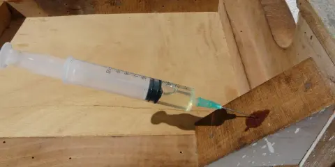 Jeringa inyectando líquido para eliminar carcoma en madera vieja.