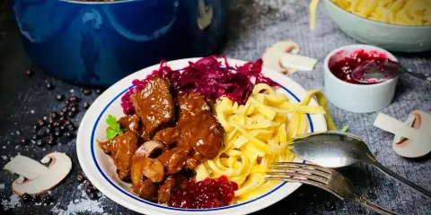Herzhaftes Rehgulasch mit Spätzle, Rotkohl und Preiselbeeren. Ein köstliches Rehgulasch Rezept für Genießer.