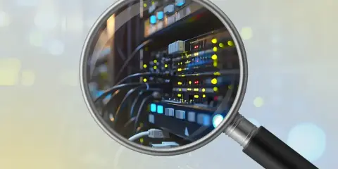 Lupe über Server-Rack, um die BIOS-Version auszulesen. Leuchtende LEDs und Kabel sind sichtbar.