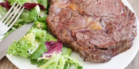 Une succulente côte de bœuf, parfaitement saisie, accompagnée d'une salade fraîche et croquante. Un délice à savourer !