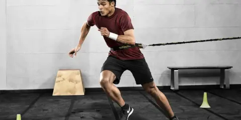 Mann trainiert mit Widerstandsband für explosive Kraft. Sein Lunge Sport ist intensiv.