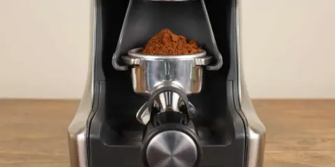 Nahaufnahme des Siebträgers mit frisch gemahlenem Kaffee, bereit zur Einstellung des Sage Smart Grinder Pro.