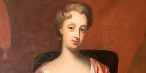 Porträtt av Christina Piper i rosa klänning, med en mjuk blick och uppsatt hår.
