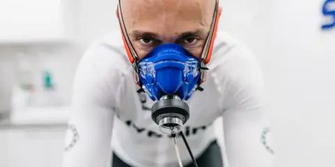 Mężczyzna w masce do testów wydolnościowych, badanie VO2 max. Intensywny wysiłek w celu poprawy kondycji.