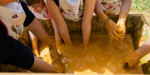 Des enfants s'amusent dans la boue, une super activité enfant Vaucluse pour explorer et créer.