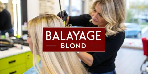 Une coiffeuse applique un balayage blond sur les cheveux d'une femme.