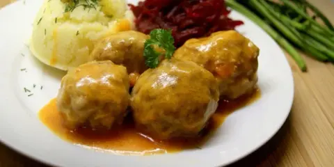Pyszne pulpety w sosie pomidorowym, podane z puree ziemniaczanym, buraczkami i zielonymi warzywami.