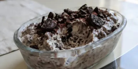 Pyszne lody oreo w szklanej misie, posypane pokruszonymi ciastkami i kakao. Idealne na deser!