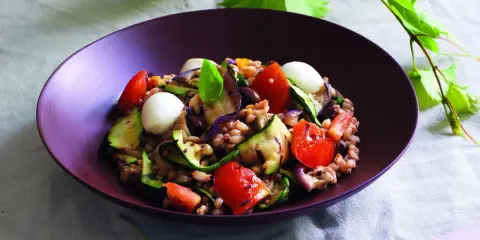 Insalata di farro estiva con verdure grigliate, pomodorini, mozzarelline e basilico, un piatto fresco e colorato.