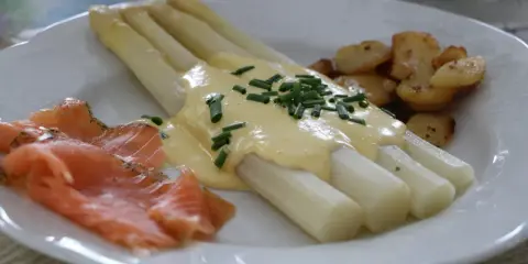 Asperges blanches nappées de sauce hollandaise, accompagnées de saumon fumé et de pommes de terre sautées. Un délice !