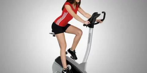 Donna su cyclette, allenamento gambe prima e dopo. Tonifica e scolpisci con l'esercizio.