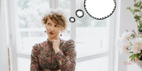 Kobieta z burzą loków zastanawia się, co powiedzieć. "Hello, my name is..." - myśli.