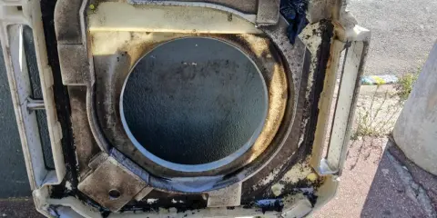 Bac à condensats d'une clim Mitsubishi très encrassé, prêt pour un nettoyage en profondeur.