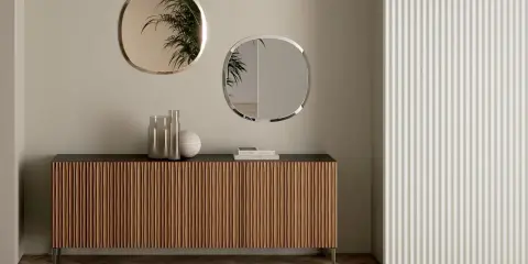 Come arredare una madia moderna: due specchi ovali e vasi decorativi creano un punto focale elegante.