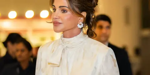 Queen Rania's elegant style shines in a cream, floral-patterned blouse with a chic pussy-bow.