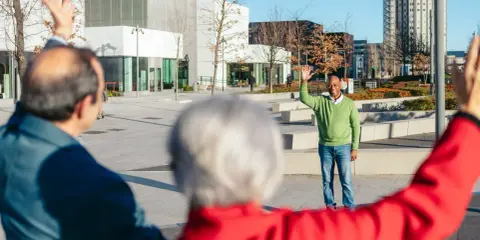 Trzech seniorów wita się na placu. To inspiracja, jak założyć klub seniora i budować społeczność.