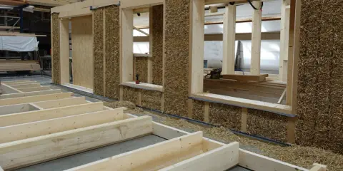 Holzkonstruktion mit Strohballenwänden im Bau. Die natürlichen holz eigenschaften machen es zu einem idealen Baustoff für nachhaltige Häuser.