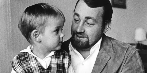 Cornelis Vreeswijk med sitt barn i en rutig väst. En varm stund mellan far och son.