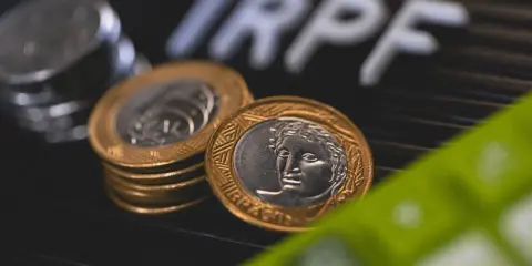 Monedas y calculadora, sugiriendo la tributación de un plan de pensiones.