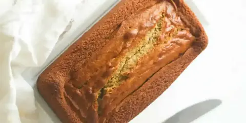 Un délicieux gâteau banane moelleux, tout juste sorti du four, prêt à être dégusté. Sa croûte dorée promet une texture parfaite.