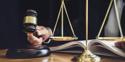 Młotek sędziowski i waga sprawiedliwości symbolizują ustalanie wielkości nabywanego udziału w rzeczy lub w prawie majątkowym.