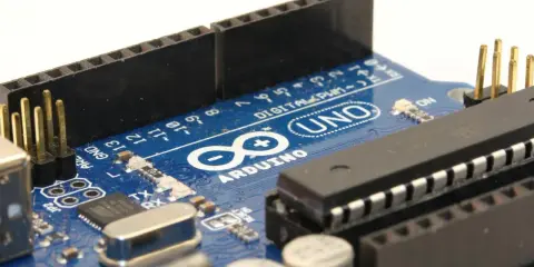 Primo piano di una scheda Arduino Uno, con il nome "ARDUINO" ben visibile. Ideale per progetti di elettronica.
