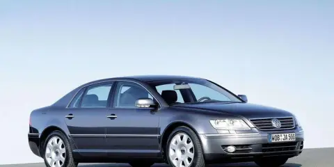Elegancki, ciemnoszary VW Phaeton W12 z lat 2002-2006 prezentuje się na tle błękitnego nieba.