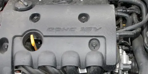 Silnik samochodowy z napisem DOHC 16V. DOHC to skrót od "Double Overhead Camshaft", co oznacza podwójny wałek rozrządu umieszczony nad głowicą.
