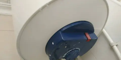 El termo gotea por abajo, mostrando una fuga de agua en la parte inferior del calentador.