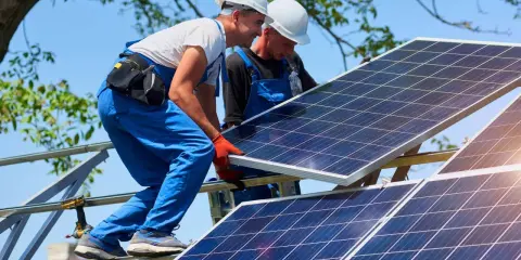 Dwóch monterów instaluje panele fotowoltaiczne. Zastanawiasz się, ile to kw? 10 kwp to moc szczytowa instalacji.