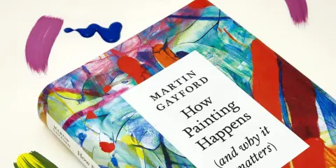 A book titled "How Painting Happens" by Martin Gayford, featuring a vibrant, abstract cover that evokes the spirit of figurative painting. Splatters of paint surround it.