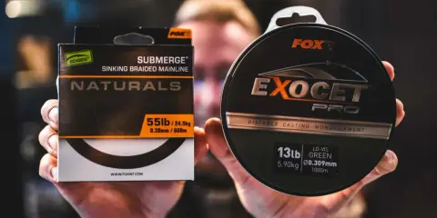 Dłonie trzymają pudełko z plecionką Fox Submerge Naturals i szpulę żyłki Fox Exocet Pro.