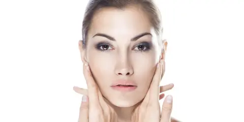 Viso di donna con mani che accarezzano le guance. Ci si chiede: dermamelan dopo quanto fa effetto per una pelle perfetta?