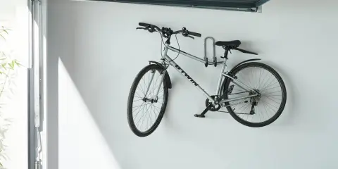 Srebrny rower zawieszony na ścianie, pokazujący, jak powiesić rower pod sufitem. Oszczędność miejsca w garażu.