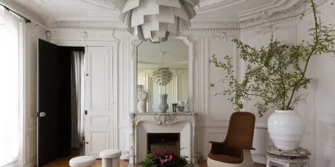 Salotto parigino con dettagli in stucco e specchio, in un elegante stile haussmann.
