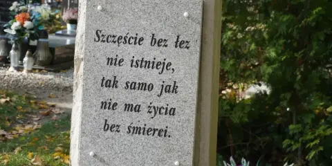 Kamienna płyta z cytatem o życiu i śmierci na cmentarzu, gdzie odbywa się pochówek urny.