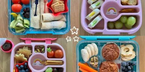Cztery kolorowe pudełka śniadaniowe z owocami, warzywami, kanapkami i muffinkami.