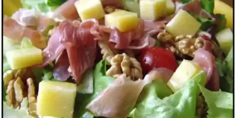Salade fraîche avec jambon cru, dés de fromage, noix et tomates cerises. Une belle entrée auvergnate pour un repas léger.