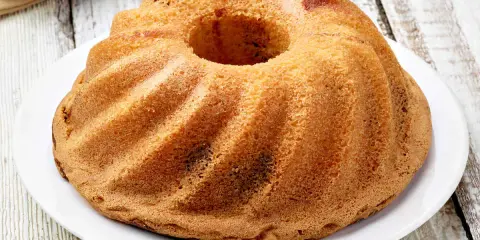 Ciambellone senza uova dorato e soffice, con la sua forma a ciambella, pronto per essere gustato.