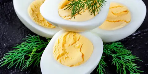 Huevos duros perfectamente cocidos y fáciles de pelar, adornados con eneldo fresco.