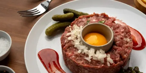 Tartar de salchichón: carne picada, huevo, pepinillos, cebolla, alcaparras y salsa. ¡Ingredientes perfectos para un plato delicioso!