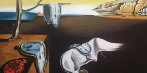 Relojes blandos, un paisaje desolado y una figura extraña, todo evoca el surrealismo de Salvador Dalí.