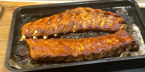 Två ugnsbakade kamben, glaserade och redo att serveras. Doften av BBQ sprider sig i köket.